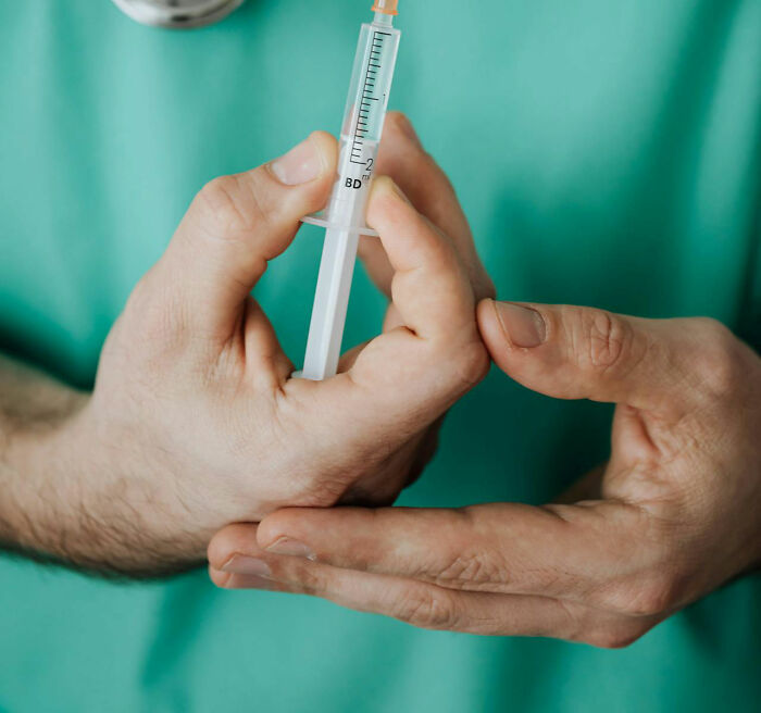 Hands holding a syringe close-up, illustrating things people said that sounded like a complete joke but were serious.