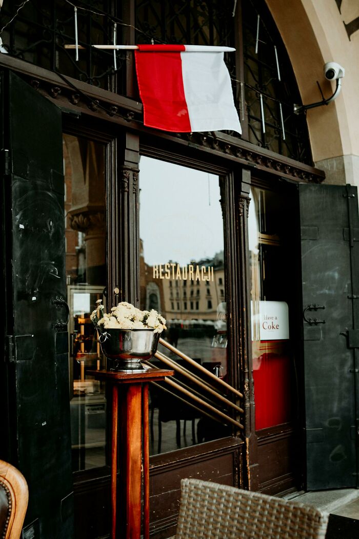 Entrance of a restaurant with a red and white flag and a flower arrangement, illustrating things people said that sounded like a joke