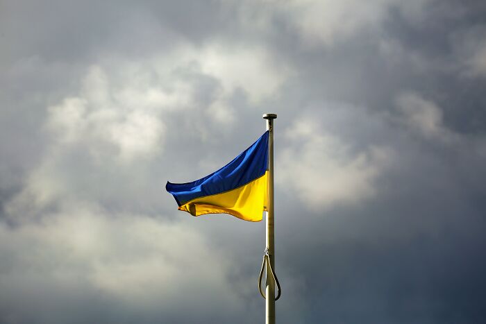 Ukrainian flag waving against a cloudy sky symbolizing vanished truths from people's home countries shared online.
