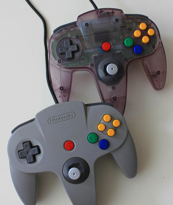 Two Nintendo 64 controllers, one gray and one translucent purple, representing dads supporting their kids with gaming.