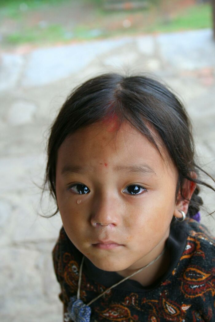 Young child with tear on cheek, showing emotional impact of horrible things medical staff saw in the ER.