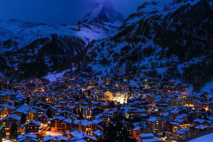 Mountain town at night covered in snow, illustrating truths that have sadly vanished from people's home countries.