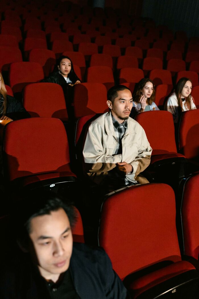 People seated quietly in a dimly lit theater, reflecting on things people said that sounded like a complete joke but were serious.