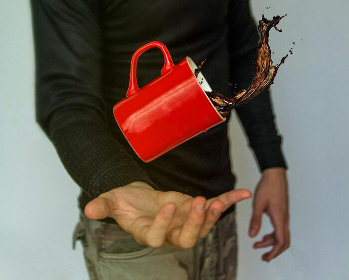 Person in black shirt spilling coffee from a red mug, illustrating disastrous first dates that make you rethink dating.