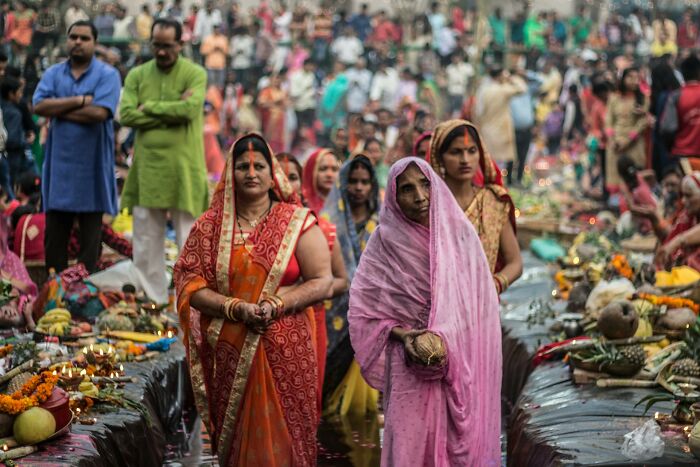 People participating in a traditional ceremony, reflecting vanished truths from people's home countries in a crowded outdoor setting.