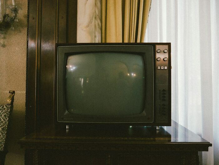 Vintage television set on wooden table in dimly lit room, evoking bizarre encounters that left viewers questioning reality.