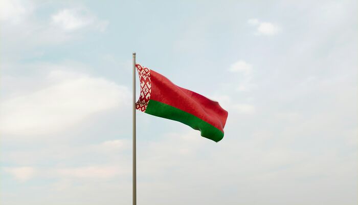 Flag of Belarus waving against a cloudy sky, illustrating truths vanished from people's home countries.