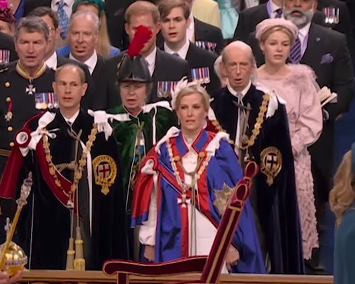 Senior royals in ceremonial attire attending a formal event, highlighting lip reader insights on Meghan Markle.