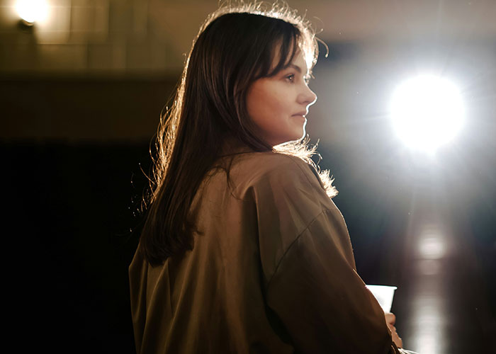 Young woman looking away with a ring light shining behind her, capturing moments of popped the question embarrassment.