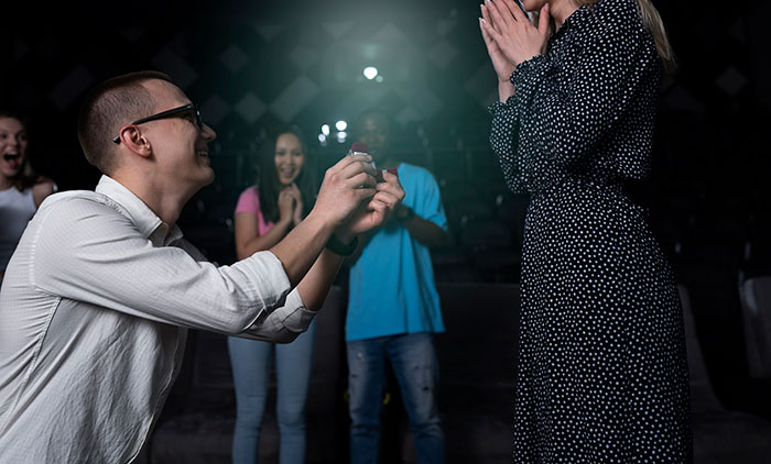 Man popping the question with a ring in a public setting, capturing a memorable engagement moment and romantic proposal.