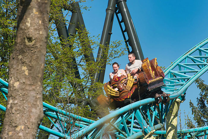 Couple on a roller coaster experiencing a thrilling moment, illustrating times people popped the question with embarrassment.