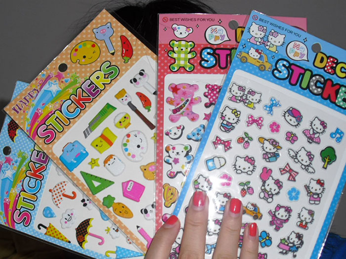 Hand holding colorful sticker packs with cute characters and childhood memories that might unlock your own memories.