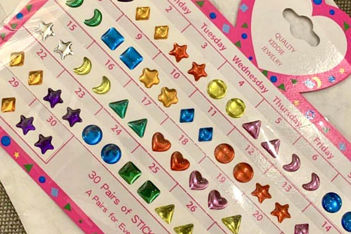 Colorful stickers shaped like stars, hearts, and moons on a calendar, evoking childhood memories and nostalgia.