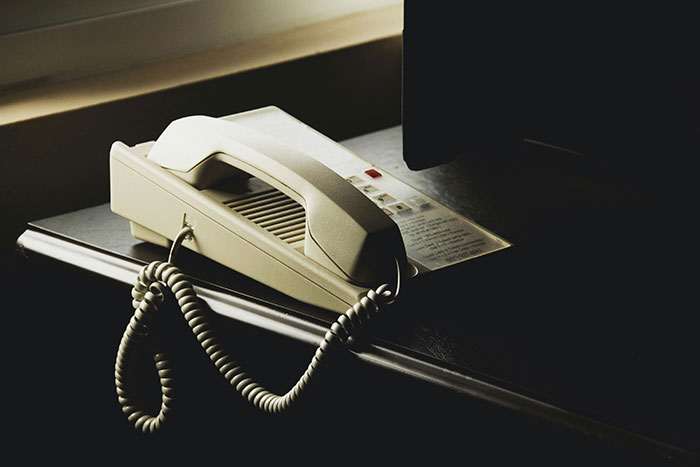 Vintage landline phone with coiled cord on a desk, evoking childhood memories and nostalgic moments from the past.