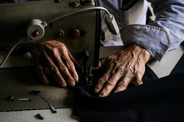 Close-up of hands working on fabric with a sewing machine, illustrating myths about iconic landmarks craftsmanship.