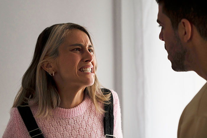 Young woman angrily confronting a man indoors, depicting tension in a secret boyfriend and sister relationship conflict.