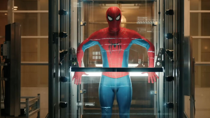 Spider-Man in his suit inside a high-tech glass chamber, showcasing Peter Parker&rsquo;s powers appearing broken and mysterious.