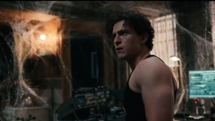 Scene from Spider-Man with Peter Parker in a dark room, highlighting why his powers look broken in the new trailer.