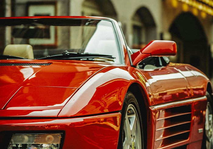 Red luxury sports car parked on a city street, showcasing a moment of true spoiled lifestyle and wealth.