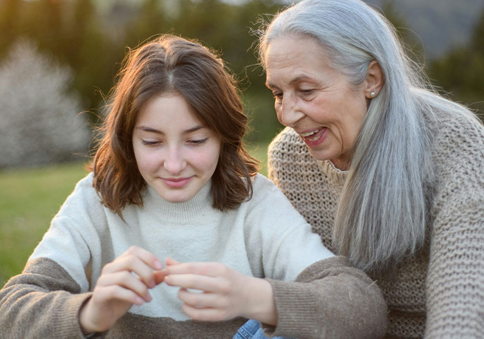 Elderly woman and young girl sharing a warm moment outdoors, illustrating eye-opening spoiled life realizations.