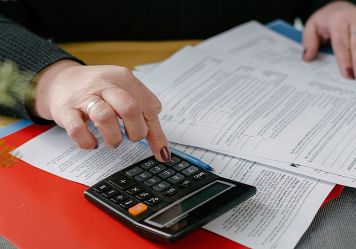 Person using calculator and reviewing documents, illustrating moments that made people realize they were truly spoiled.