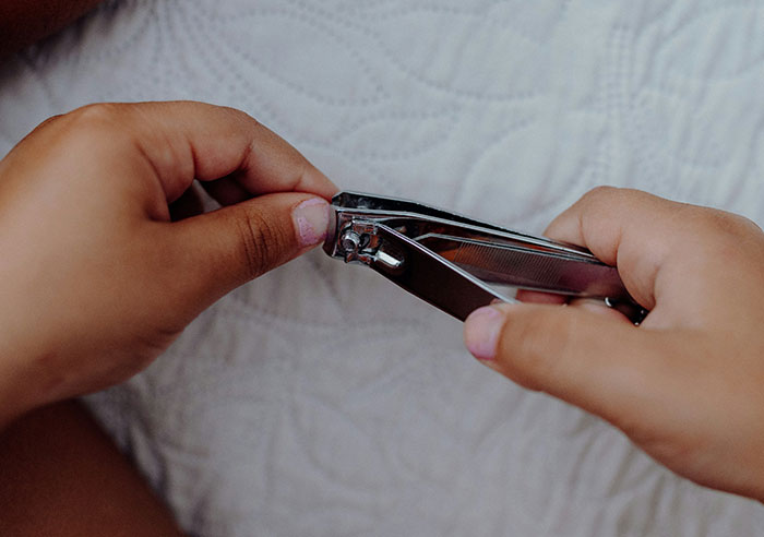 Child using nail clippers to trim fingernails, capturing a simple yet eye-opening moment of feeling spoiled.