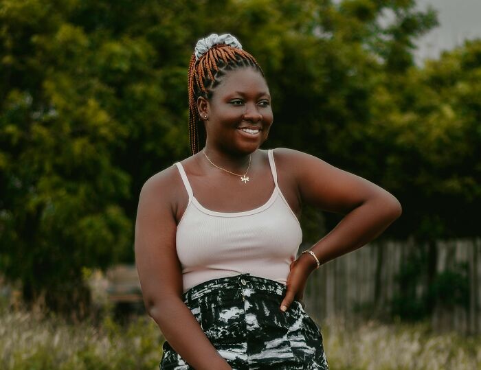 Smiling woman outdoors representing cultural things people thought were normal until visiting other countries.