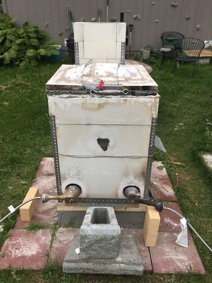 Outdoor kiln made of fire bricks and metal supports, a unique rabbit hole project explored by enthusiasts.
