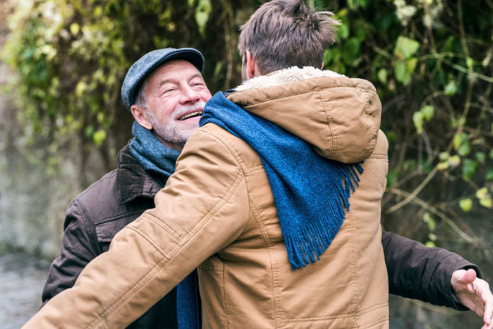 Older man and younger man embracing outdoors, symbolizing reconnecting after DNA lab mixes paternity results.