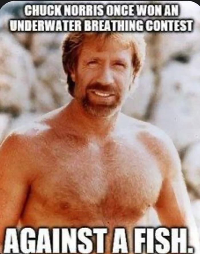 Chuck Norris meme showing him shirtless with text about winning an underwater breathing contest against a fish.