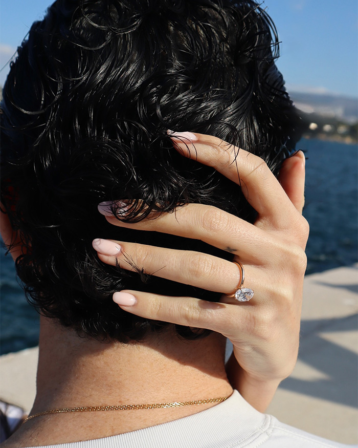 Woman showing engagement ring on hand with man, symbolizing most beautiful girl in the world and romantic proposal.