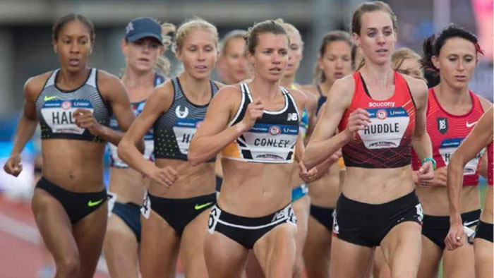 Group of female runners competing on a track, illustrating physical endurance and neurological development in adulthood.