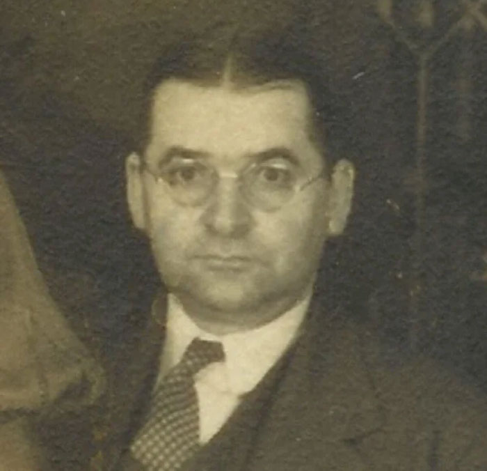 Vintage portrait of a man wearing glasses and a suit, symbolizing adults and neurological adulthood at age 32.