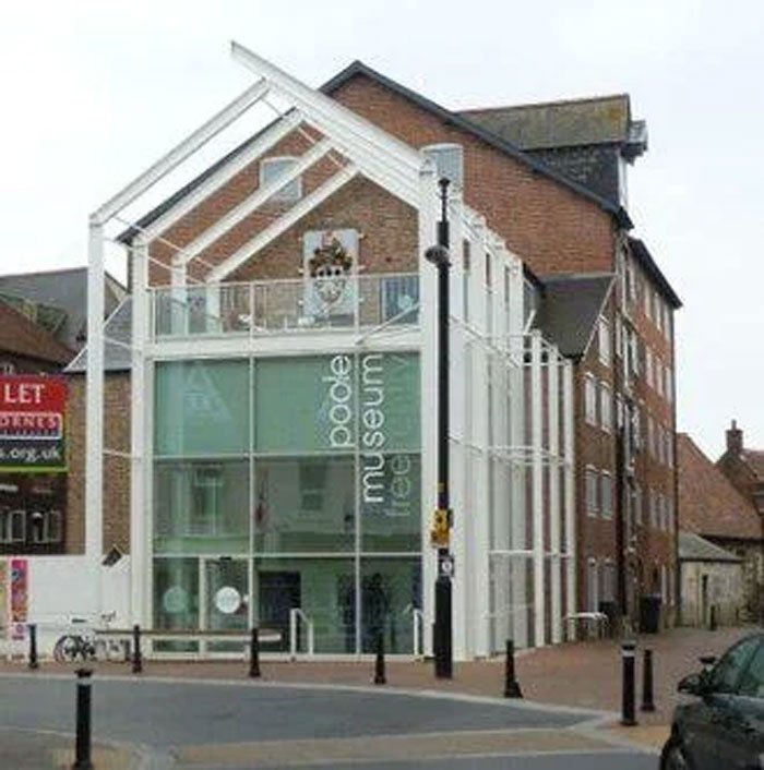 Modern building with glass facade and white frame structure, representing human neurological development and adulthood at 32 years.