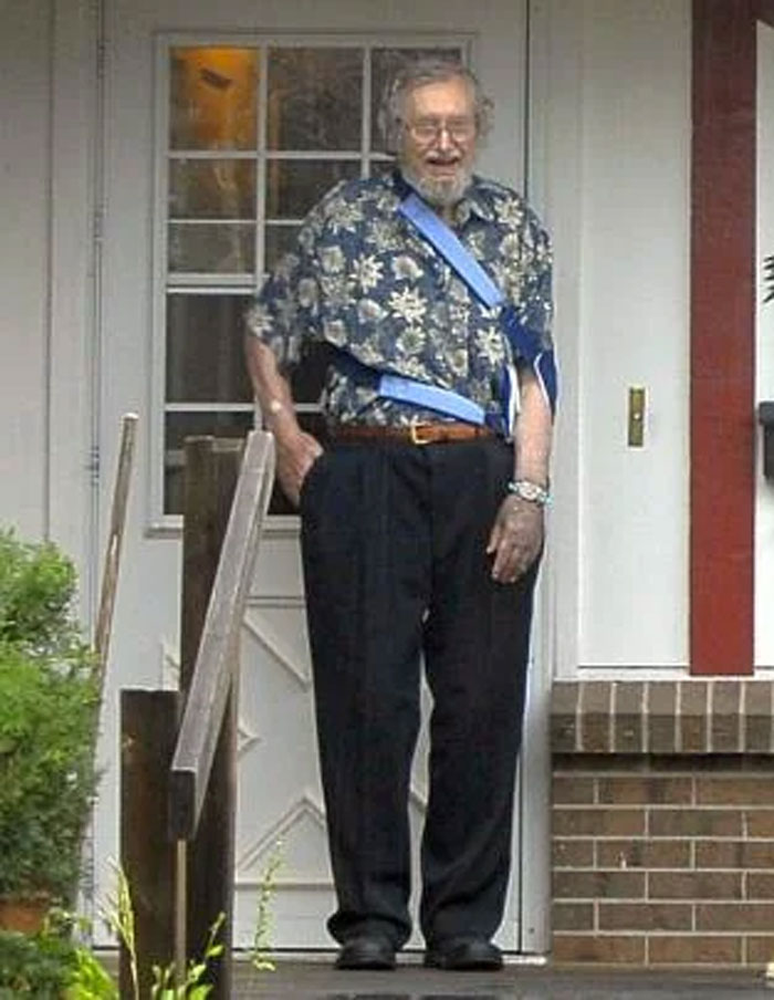 Elderly man with an arm sling standing on a porch, illustrating humans neurologically entering adulthood at age 32.
