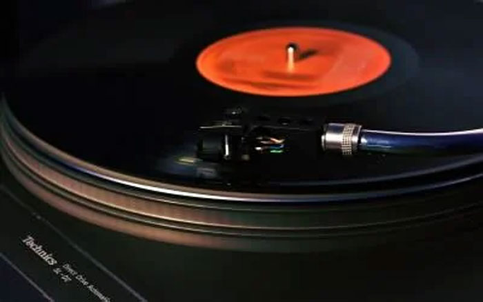 Close-up of a spinning vinyl record on a turntable illustrating the concept of humans neurologically entering adulthood at 32.