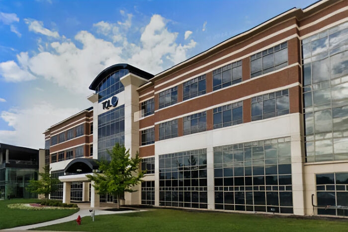 Exterior do prédio de escritórios corporativos sob o céu azul, representando a mãe que recebeu mais de 20 milhões de indenização por danos após solicitação de trabalho em casa negada.