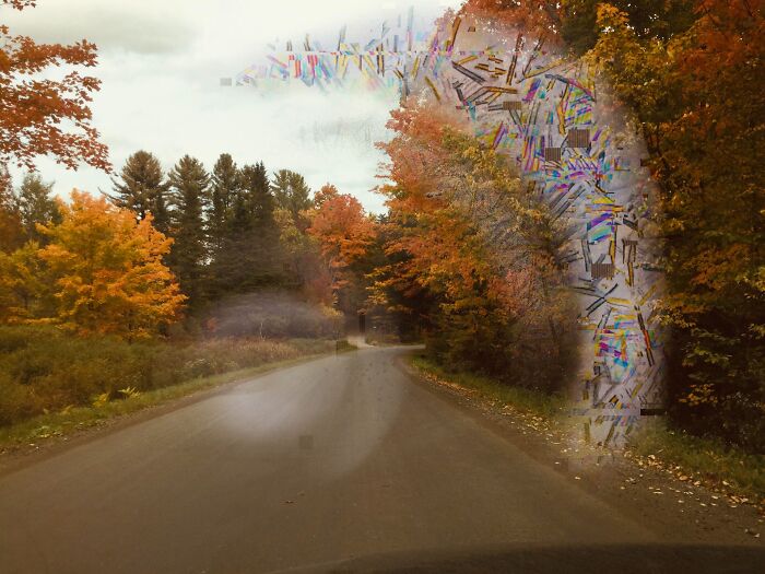 Road surrounded by autumn trees with a distorted mysterious glitch effect creating an unexplained phenomenon in nature.