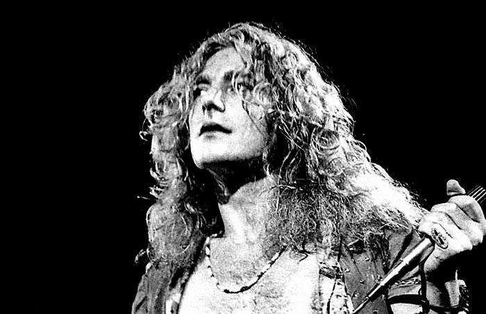 Black and white image of a one-in-a-million story musician performing passionately with a microphone on stage.