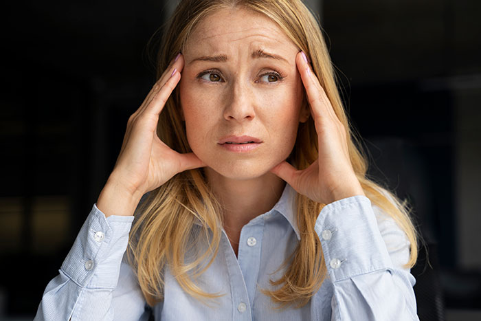 Stressed woman holding head in hands, showing frustration and tension, reflecting an unhelpful husband scenario. Stressed woman holding head in hands, showing frustration and tension, reflecting an unhelpful husband scenario.