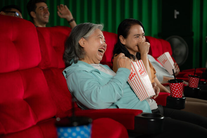 A family enjoying a movie night together, sharing popcorn and laughter, showcasing unconventional family traditions.