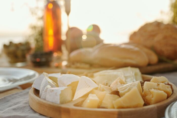 A cheese and bread platter on a table outdoors, inviting you to challenge your beliefs with controversial opinions.