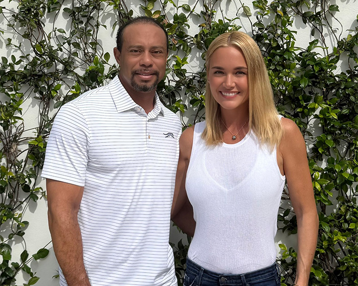 Tiger Woods and Vanessa Trump smiling outdoors in casual white tops with greenery in the background after DUI arrest news