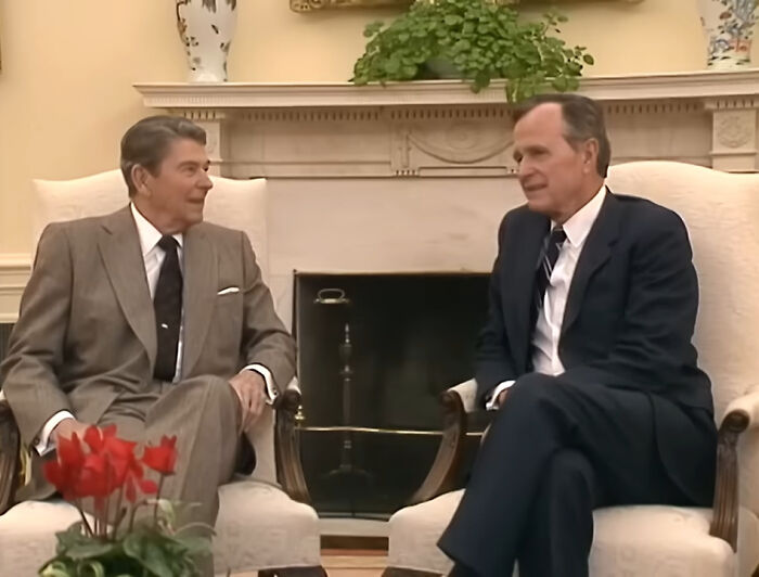 Two men in suits sitting and talking in a formal room, illustrating disturbing images and facts about real life nightmares.