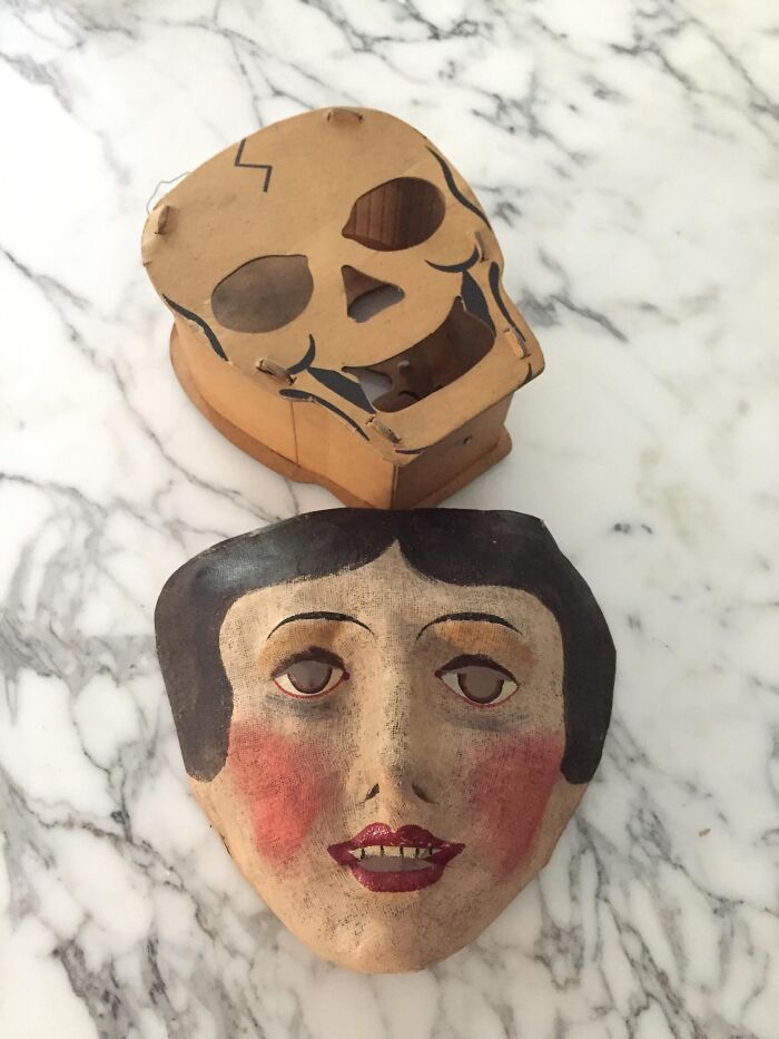 Two creepy vintage masks, one skull-shaped and one with a painted face, found in an old home with bizarre artifacts.