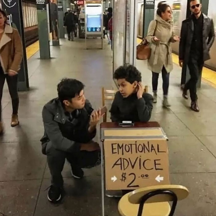 Two people offering emotional advice for $2 in a busy subway station, highlighting uplifting moments in the world.