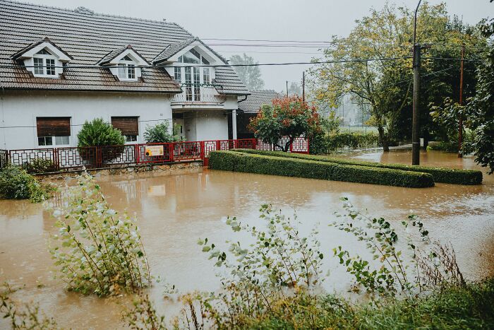 Flooded yard surrounding a house, illustrating a scary encounter in a lone living situation with rising water levels.