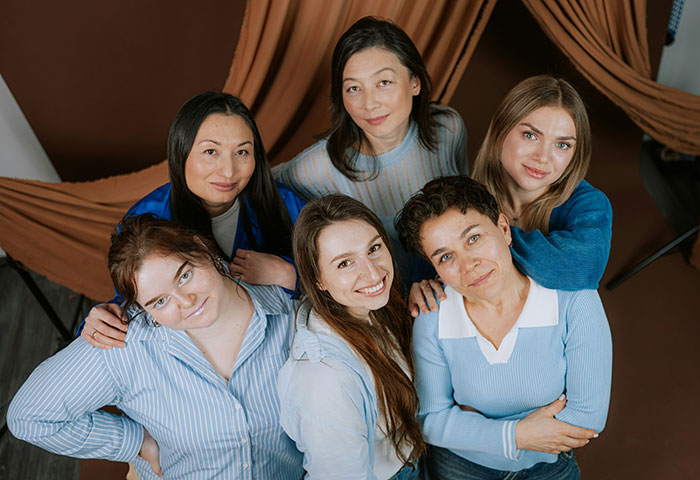 Group of women in casual clothes smiling and posing, depicting suspicious woman trusting her gut instinct concept.