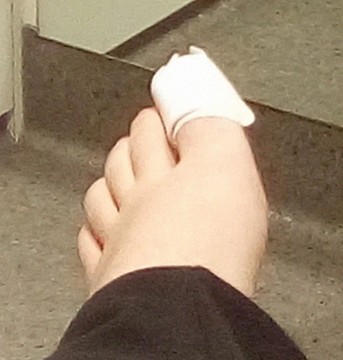Foot with a bandaged toe resting on a hospital floor, illustrating painful hospital experiences and care challenges.