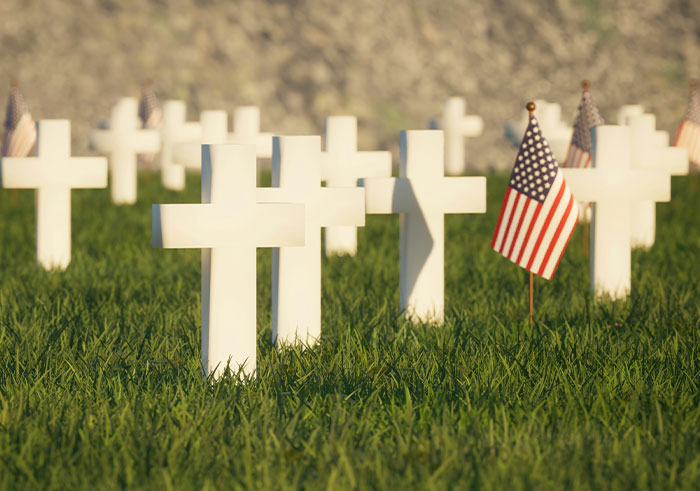 White crosses marking graves in a cemetery with American flags, reflecting memorable funeral moments that became notable.